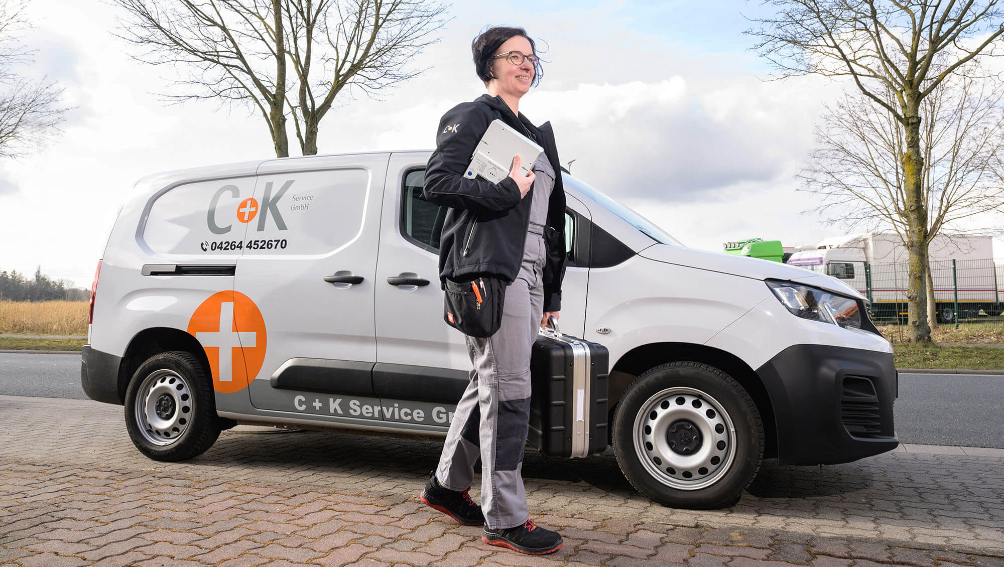 C+K Handwerkerin vor dem Betriebsauto 